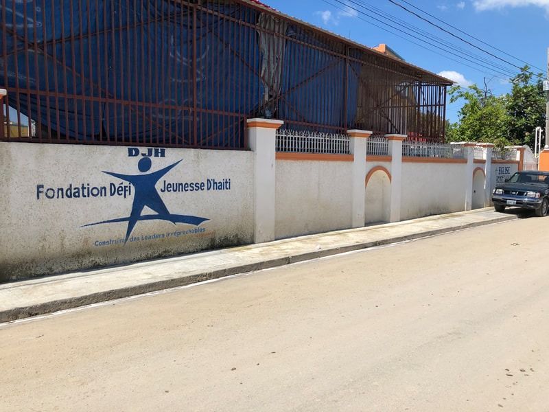 A white wall displaying the blue logo and text