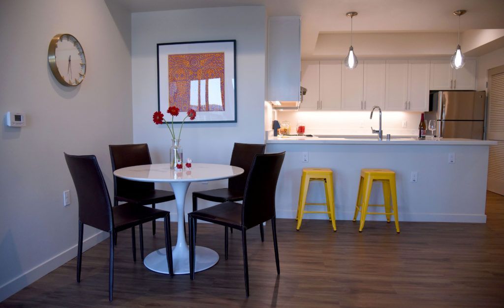 A dining room with a table and chairs and yellow stools