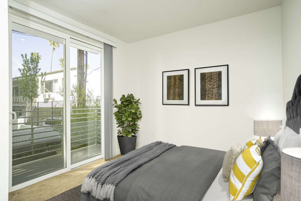 A bedroom with a large bed and sliding glass doors.