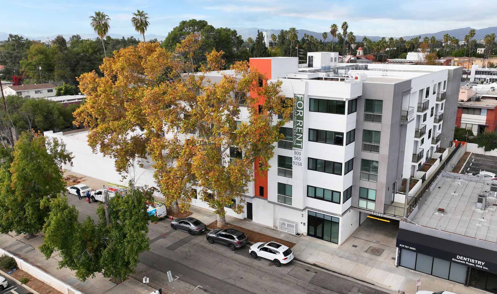 An aerial view of a building with cars parked in front of it.