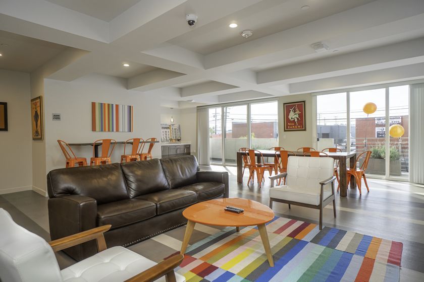 A living room with a couch , chairs , table and rug.