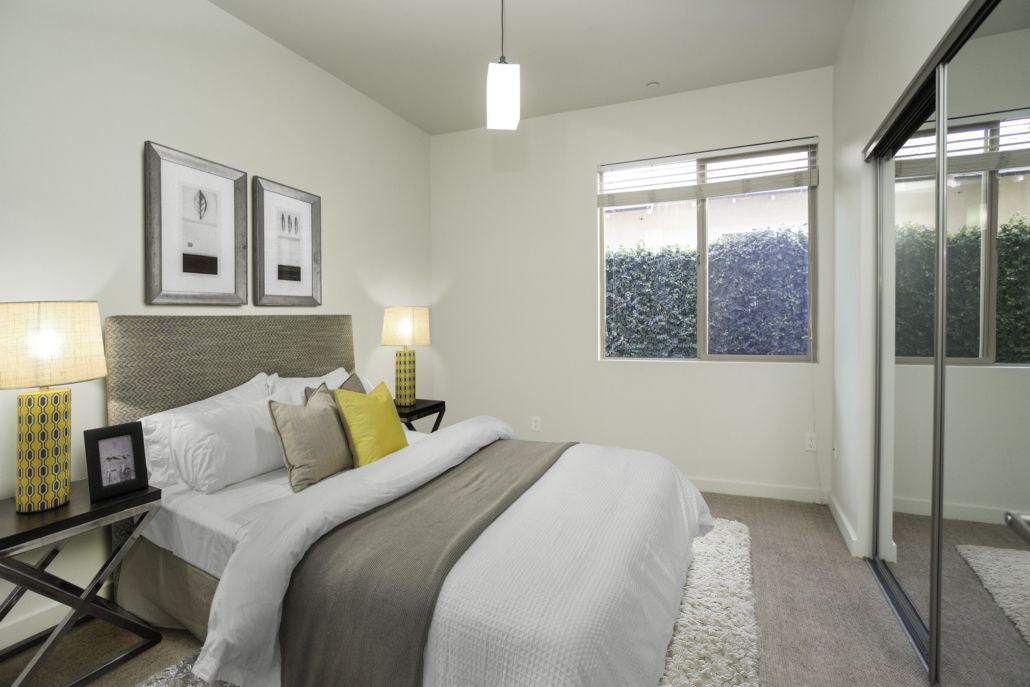 A bedroom with a large bed and a mirrored wardrobe