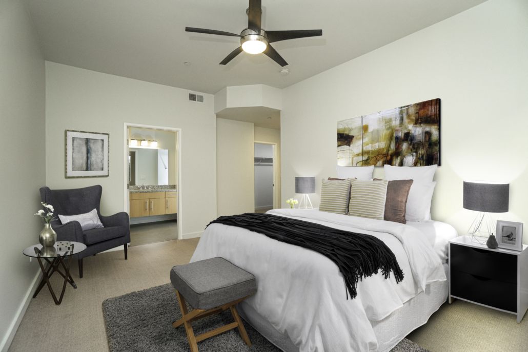 A bedroom with a large bed and a ceiling fan