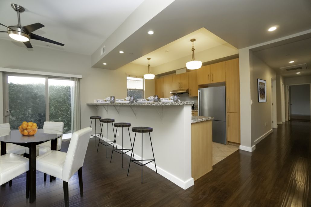 A kitchen with a table and chairs and a ceiling fan