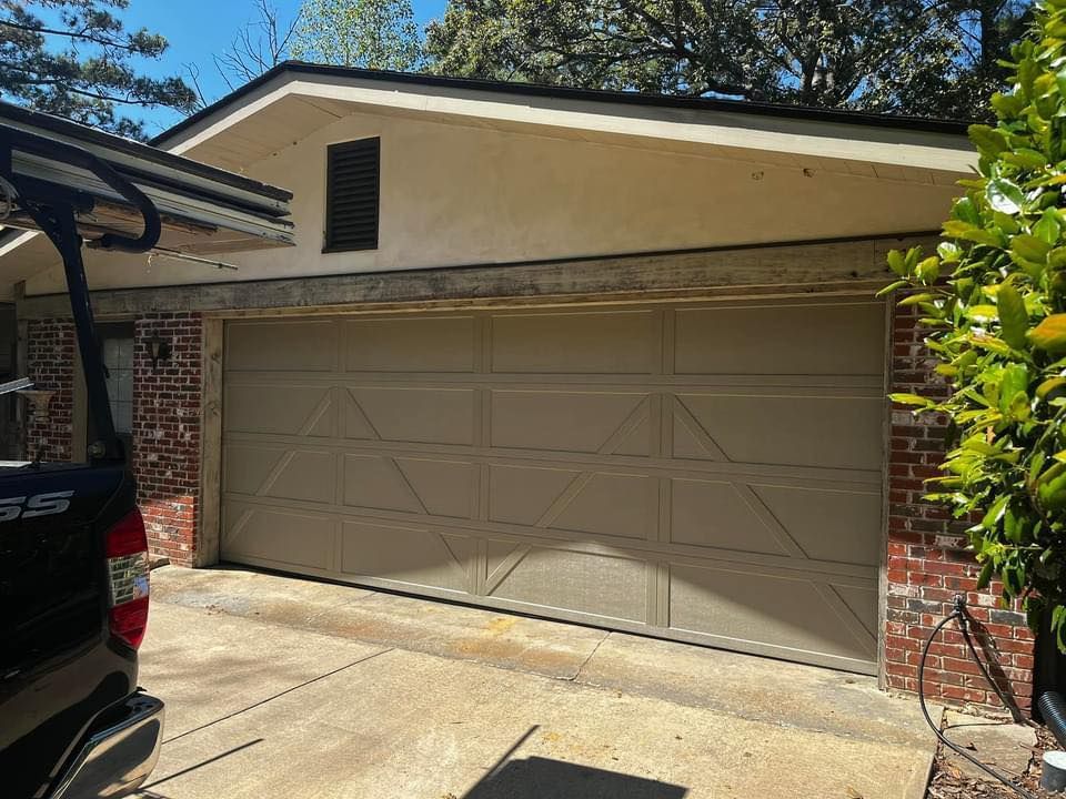 A car is parked in front of a garage door.