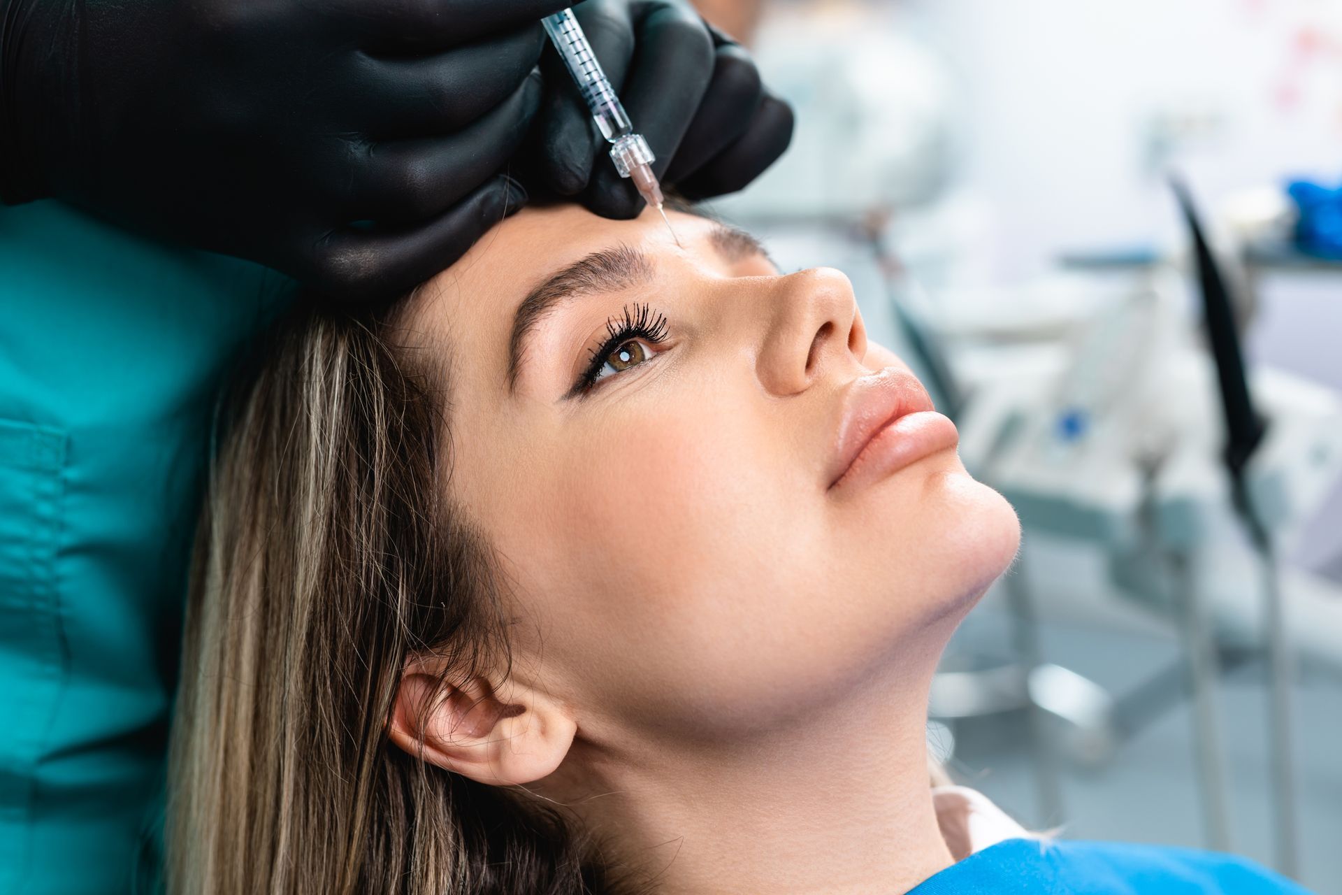 A person receiving an injection in their forehead while in a medical setting.