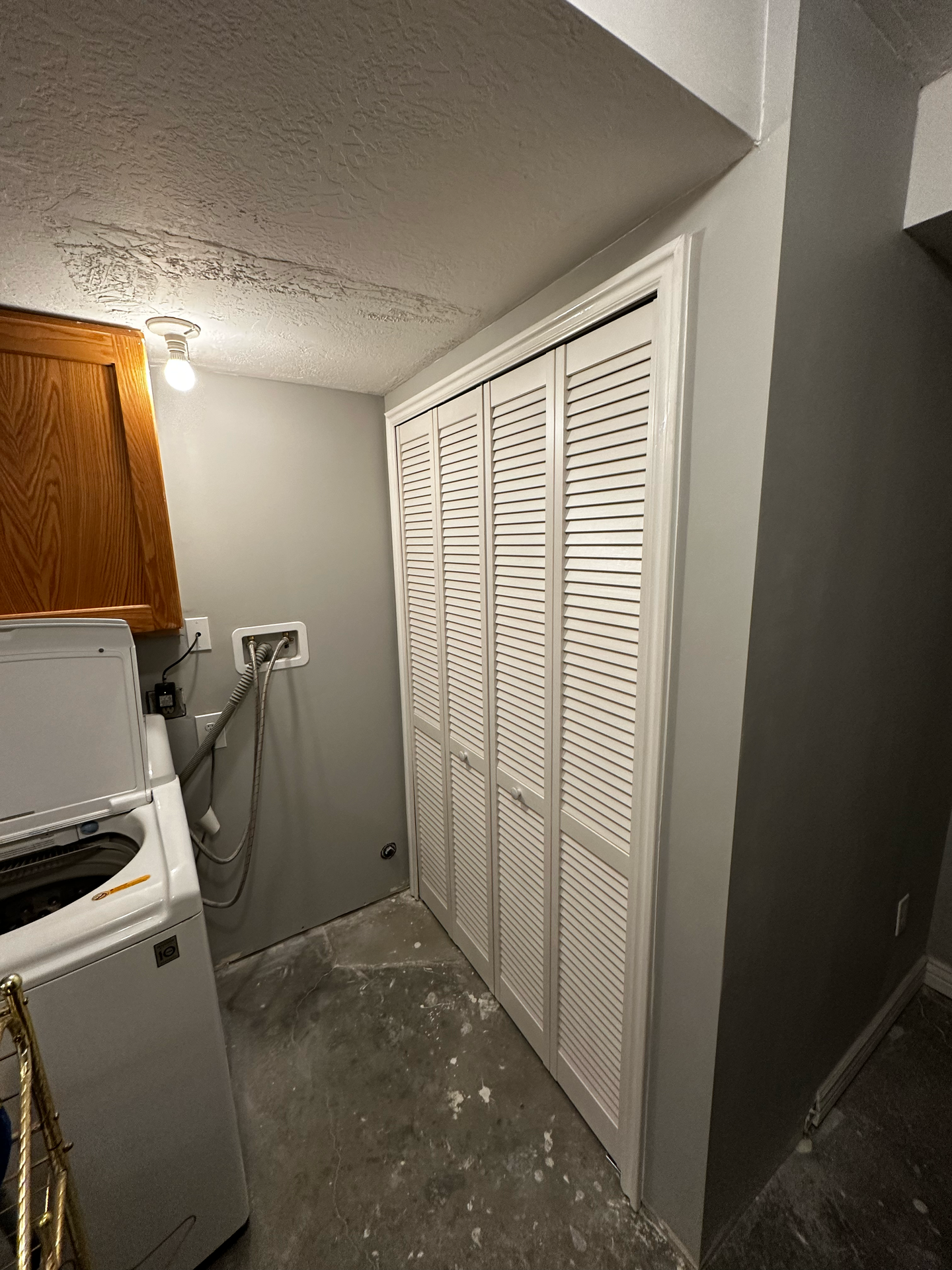 A laundry room with a washer and dryer and a closet.