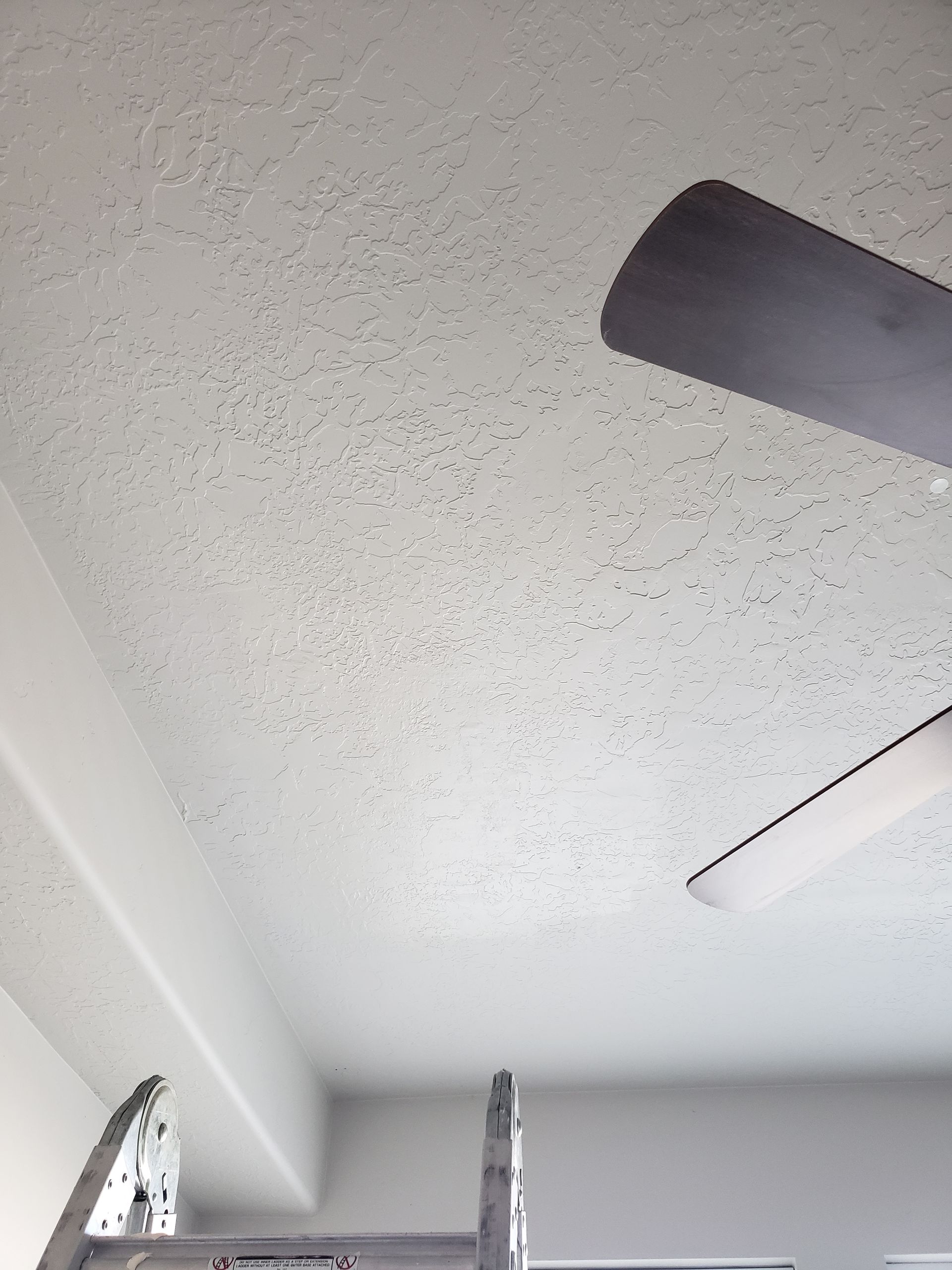 A ceiling fan is hanging from the ceiling of a room