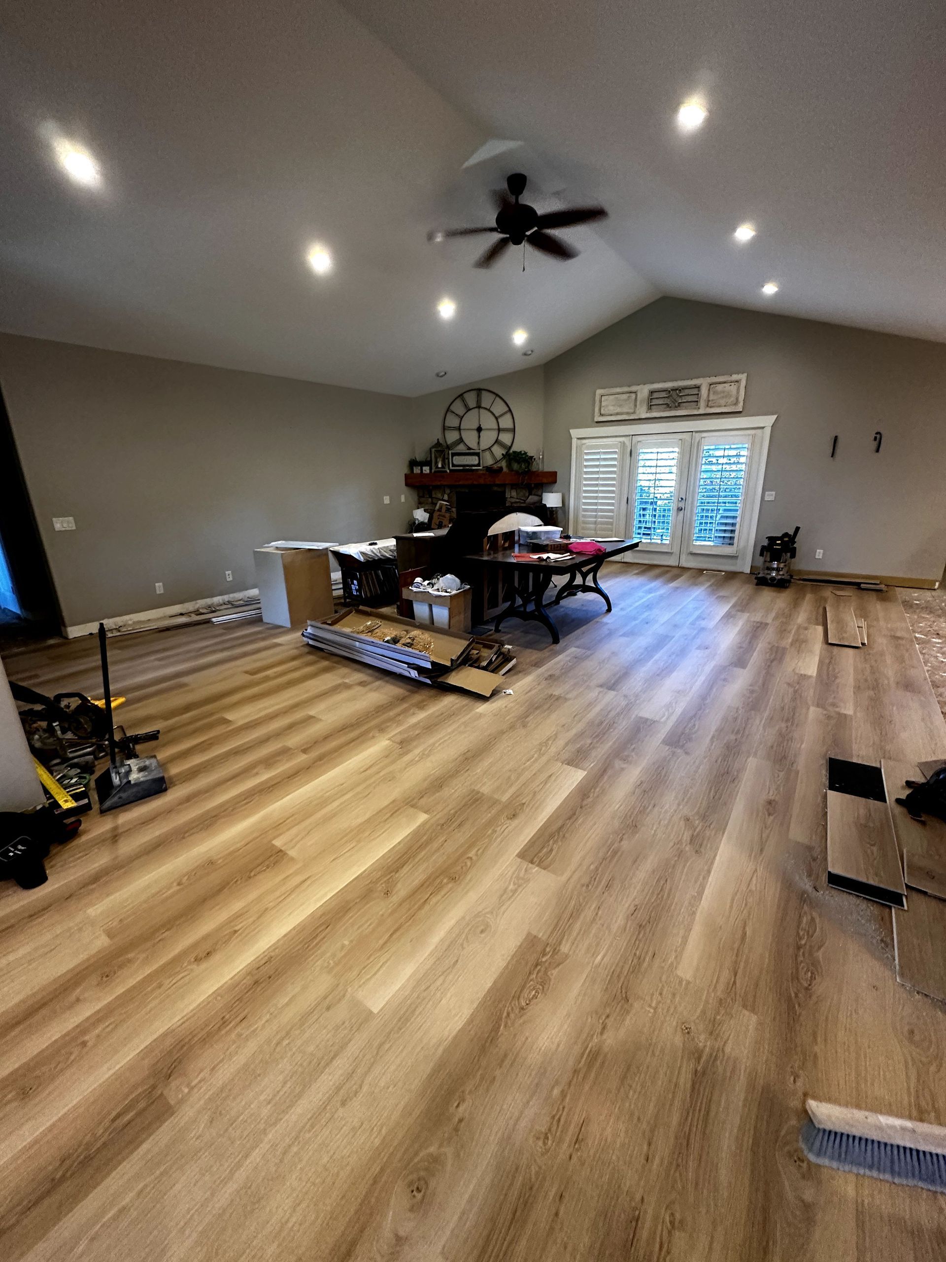 A living room with hardwood floors and a ceiling fan.