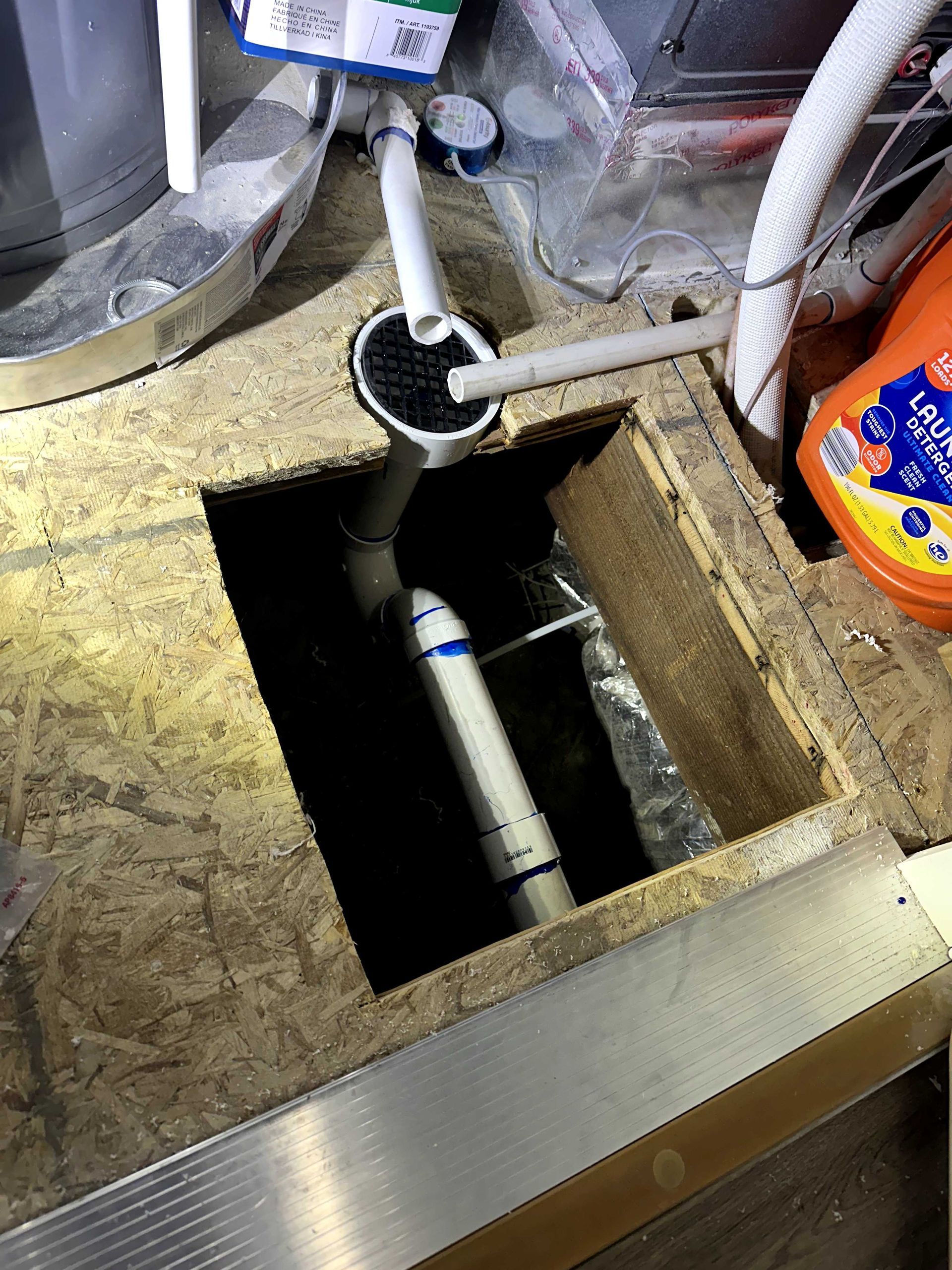 A white pipe is coming out of a hole in the floor.