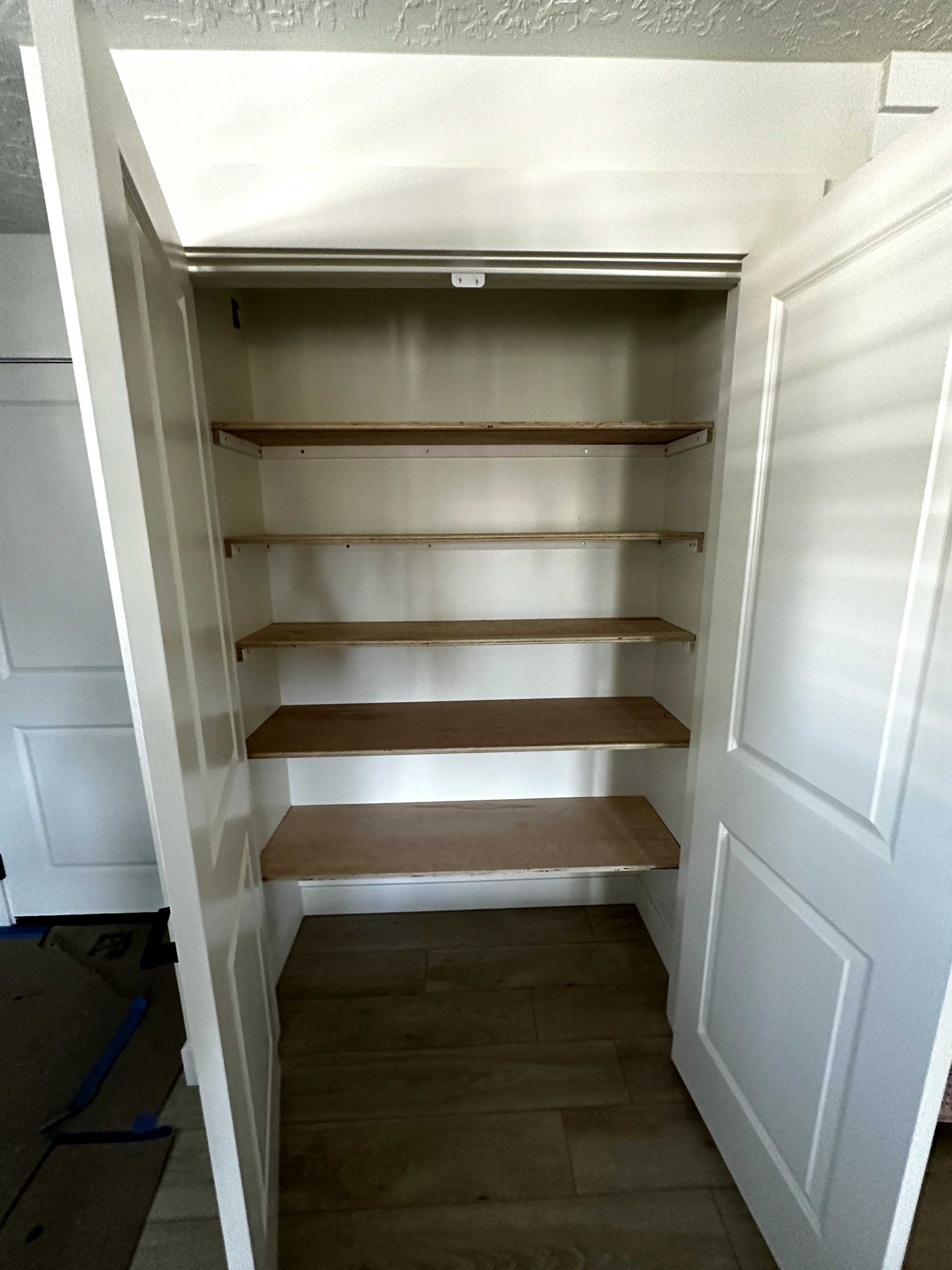 A closet with wooden shelves and a white door