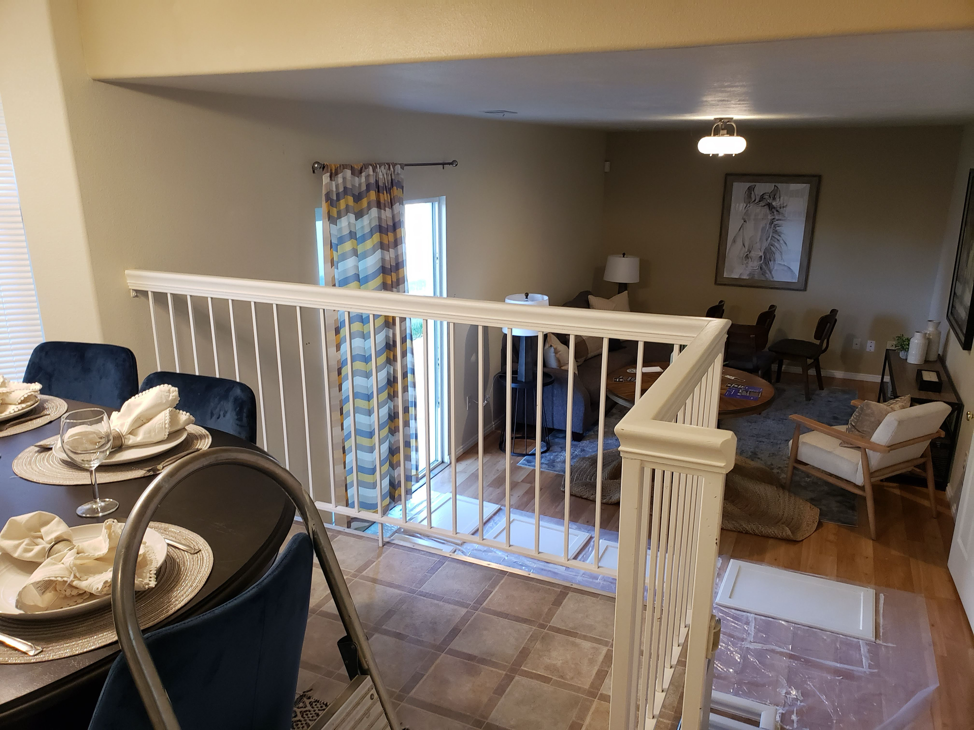 A dining room with a table and chairs and a balcony.
