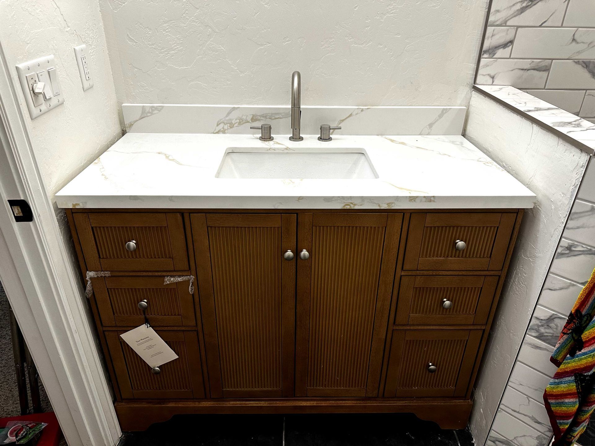 A bathroom vanity with a sink , faucet and drawers.