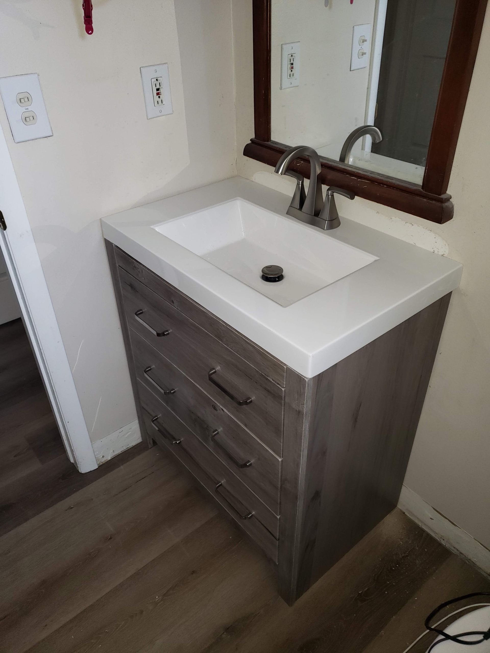 A bathroom vanity with a sink and a mirror.
