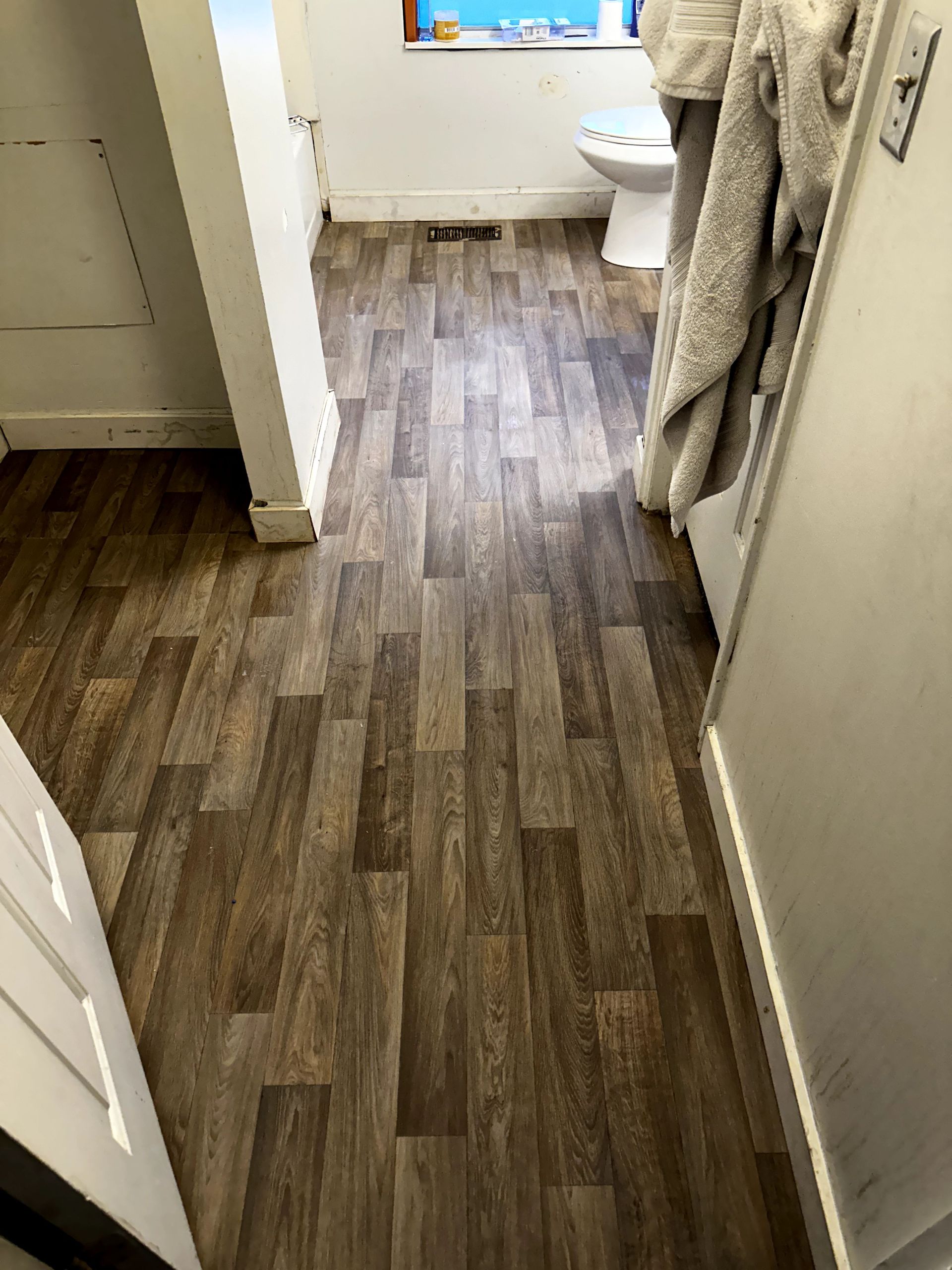A bathroom with a wooden floor and a toilet.