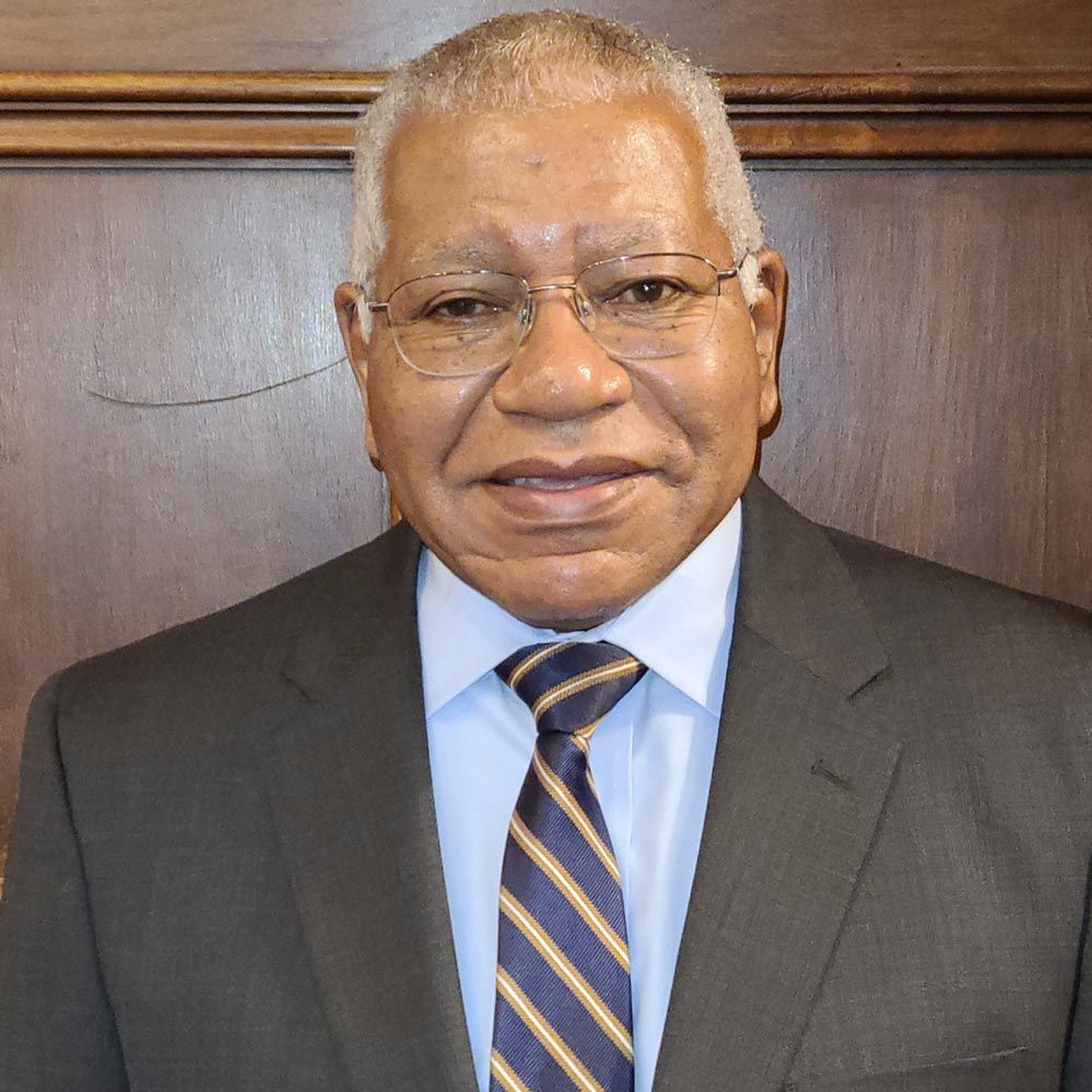A man in a suit and tie is smiling for the camera