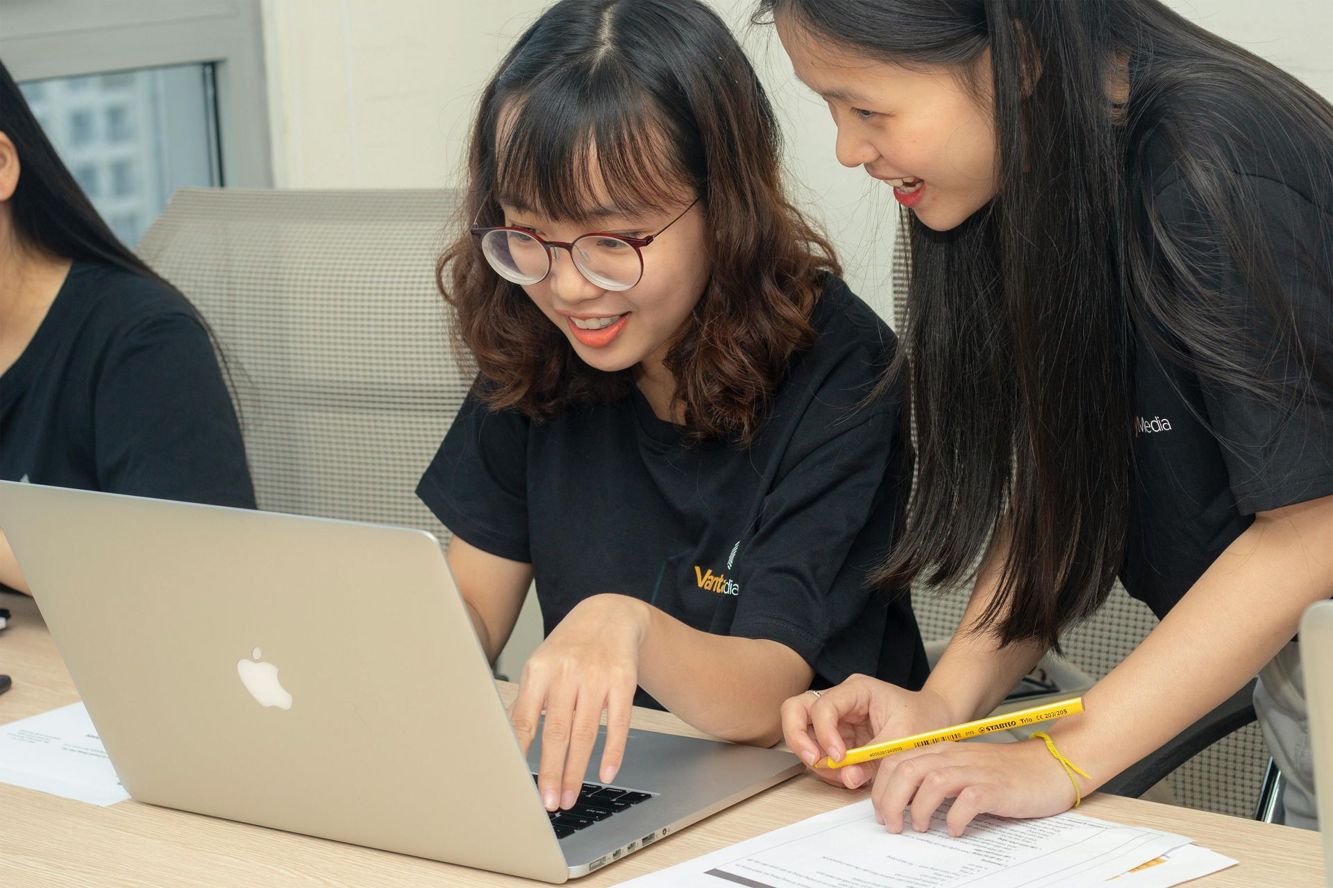 Two young women are looking at a laptop computer.