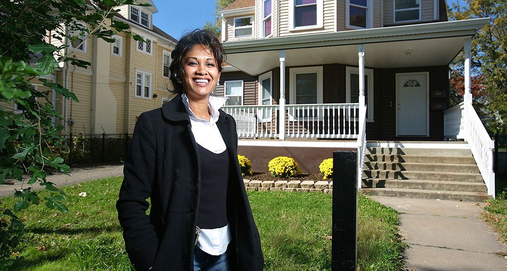 HCLF borrower Sohodra Dilchand in front of one of her renovated apartment buildings