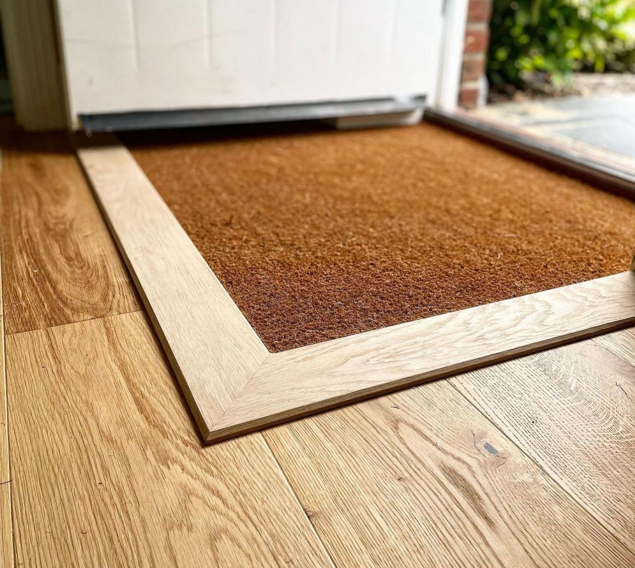 a door mat is sitting on a wooden floor next to a door .