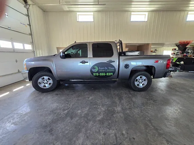 Silver pickup truck with company logo parked inside a bright garage