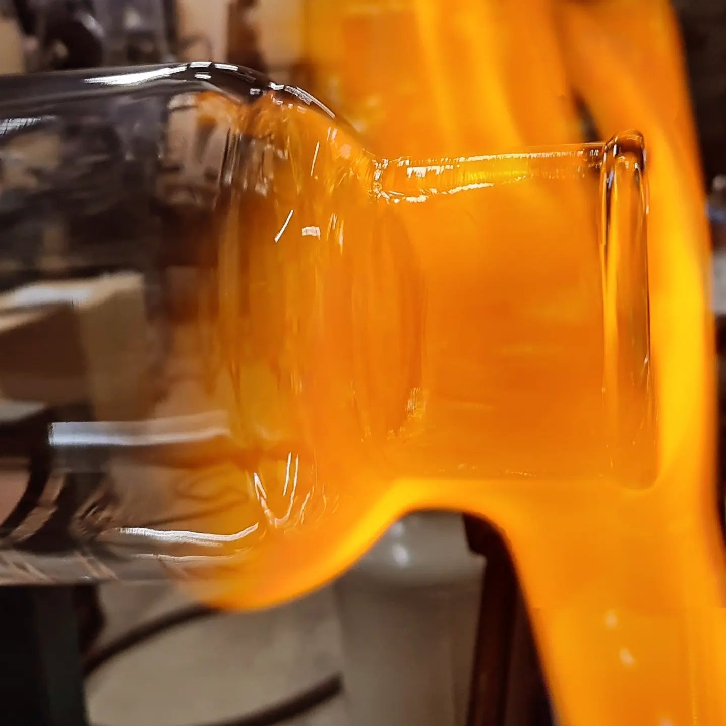 Vetro fuso modellato dalla fiamma, di colore arancione brillante.