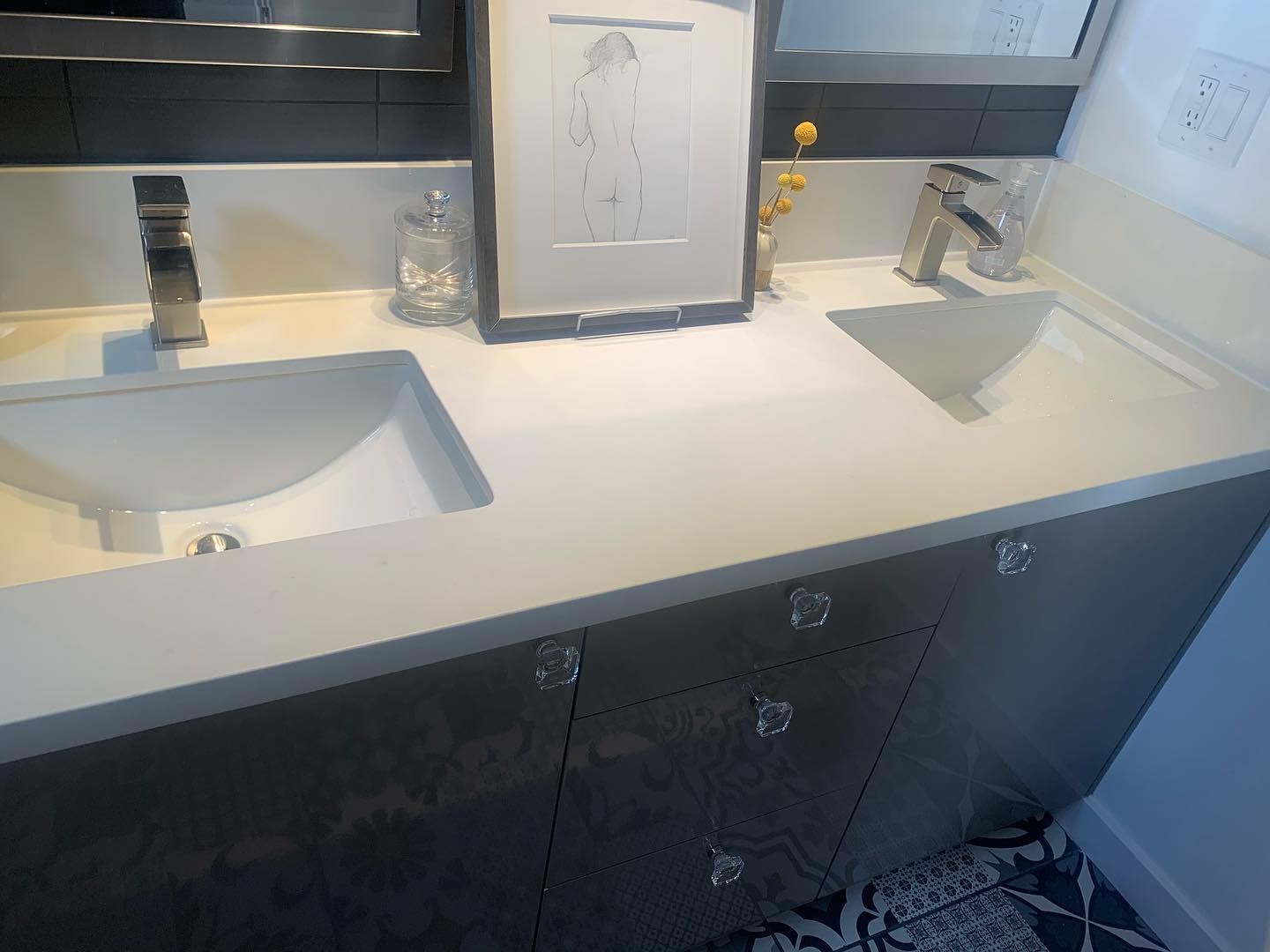 A modern bathroom vanity with two sinks, gray cabinets, and a white countertop. 