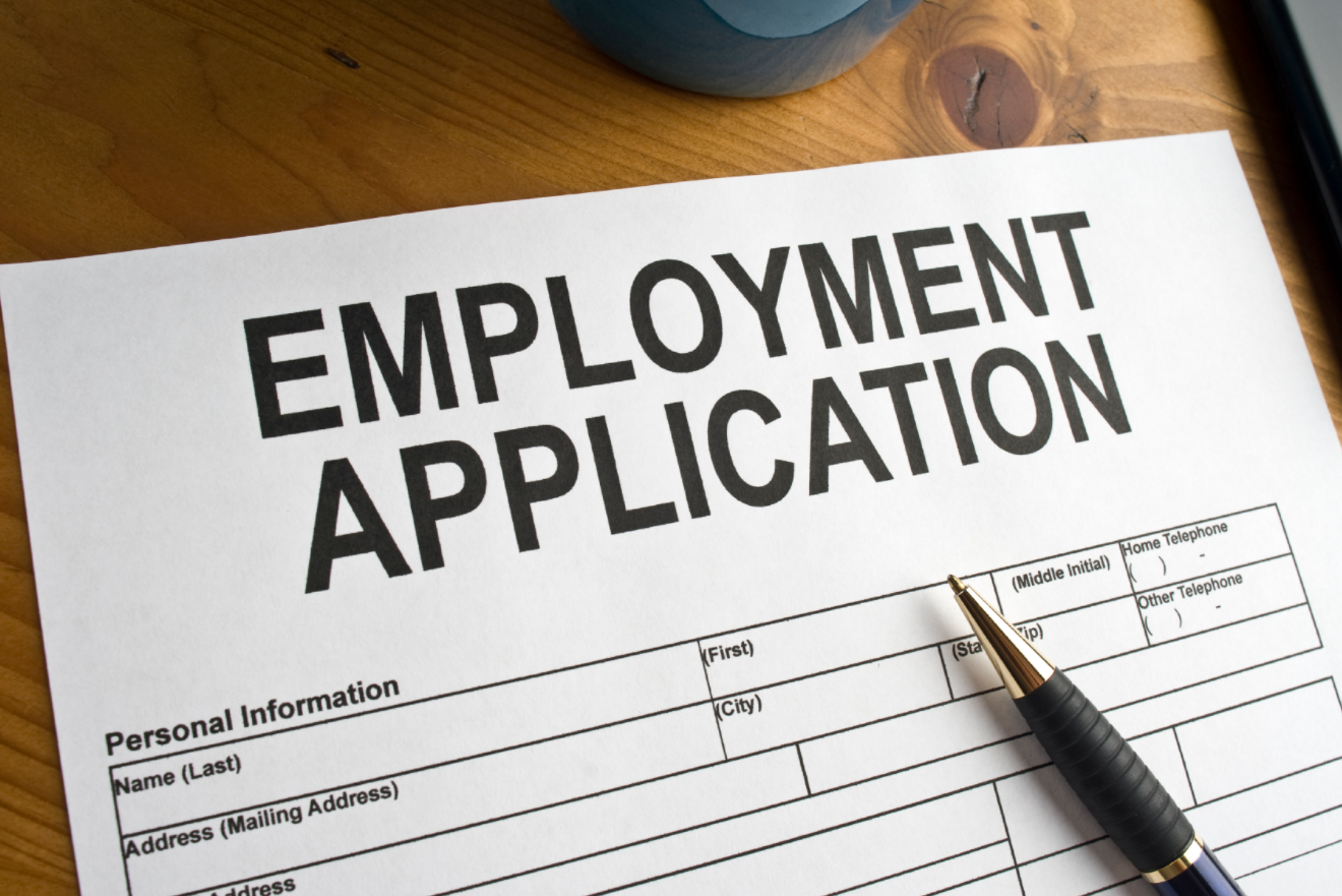 An employment application form with a pen on it