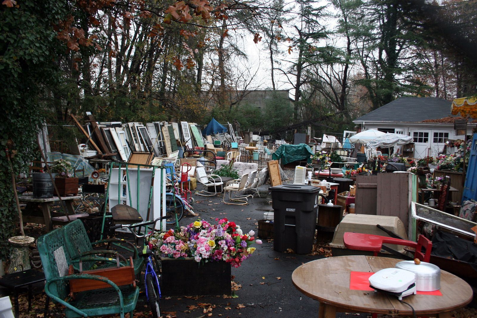 A messy yard with a table and chairs in the middle