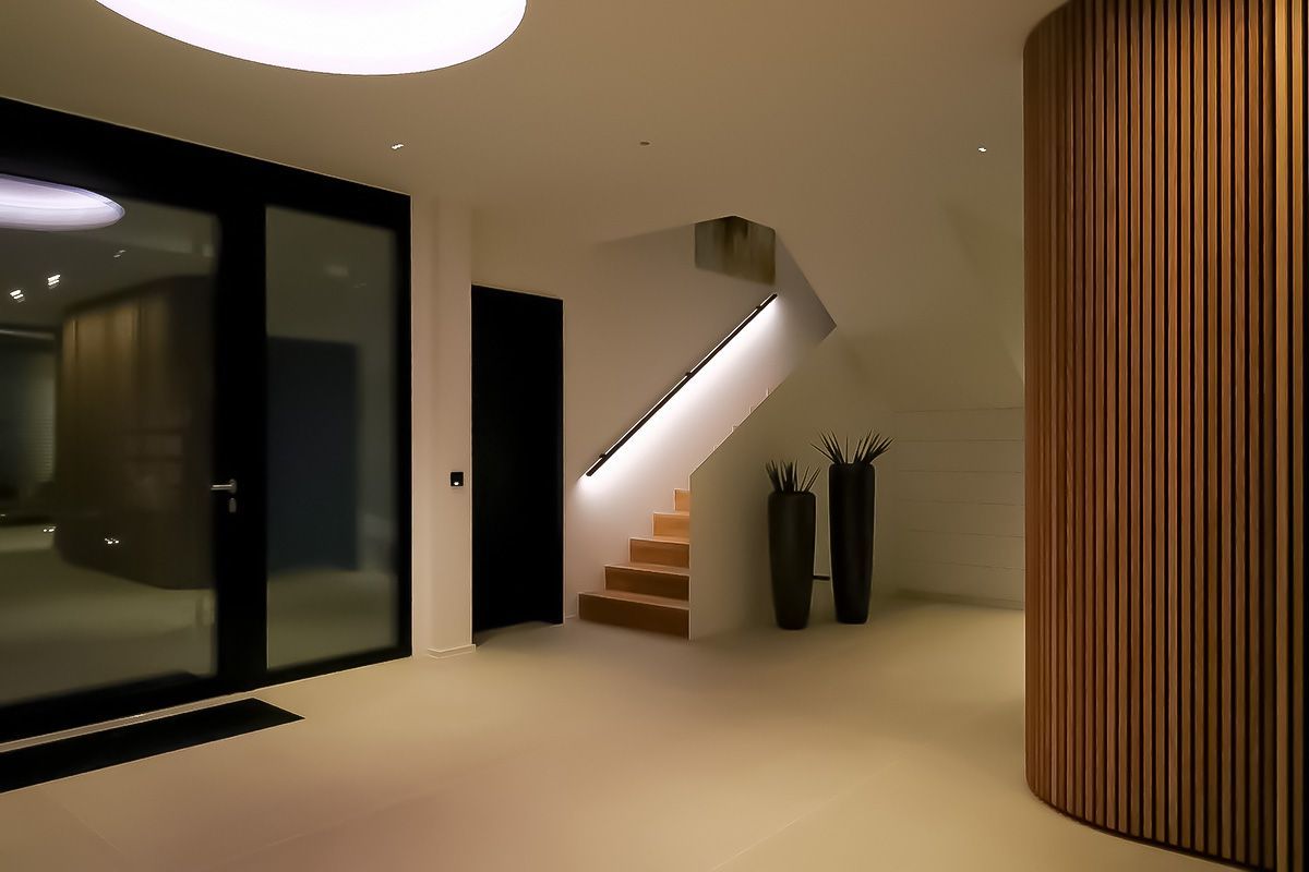Projektbeispiel: LED-beleuchteter Treppenhandlauf in einem modernen Flur mit Glastüren