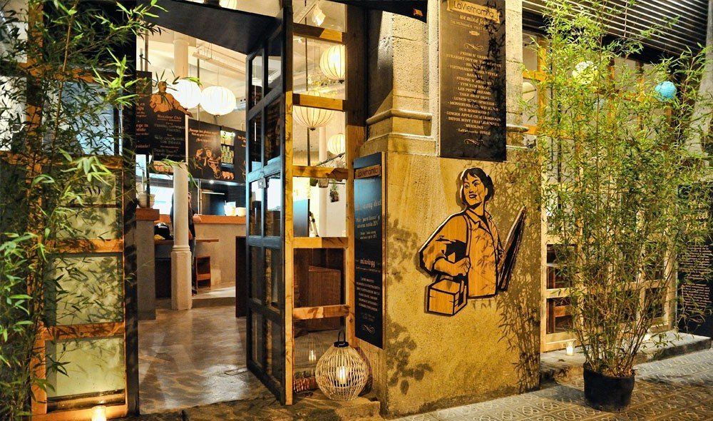 Atmosphärische Restaurant-Beleuchtung mit warmen Lampions und einer Bodenwindlichteleuchte.