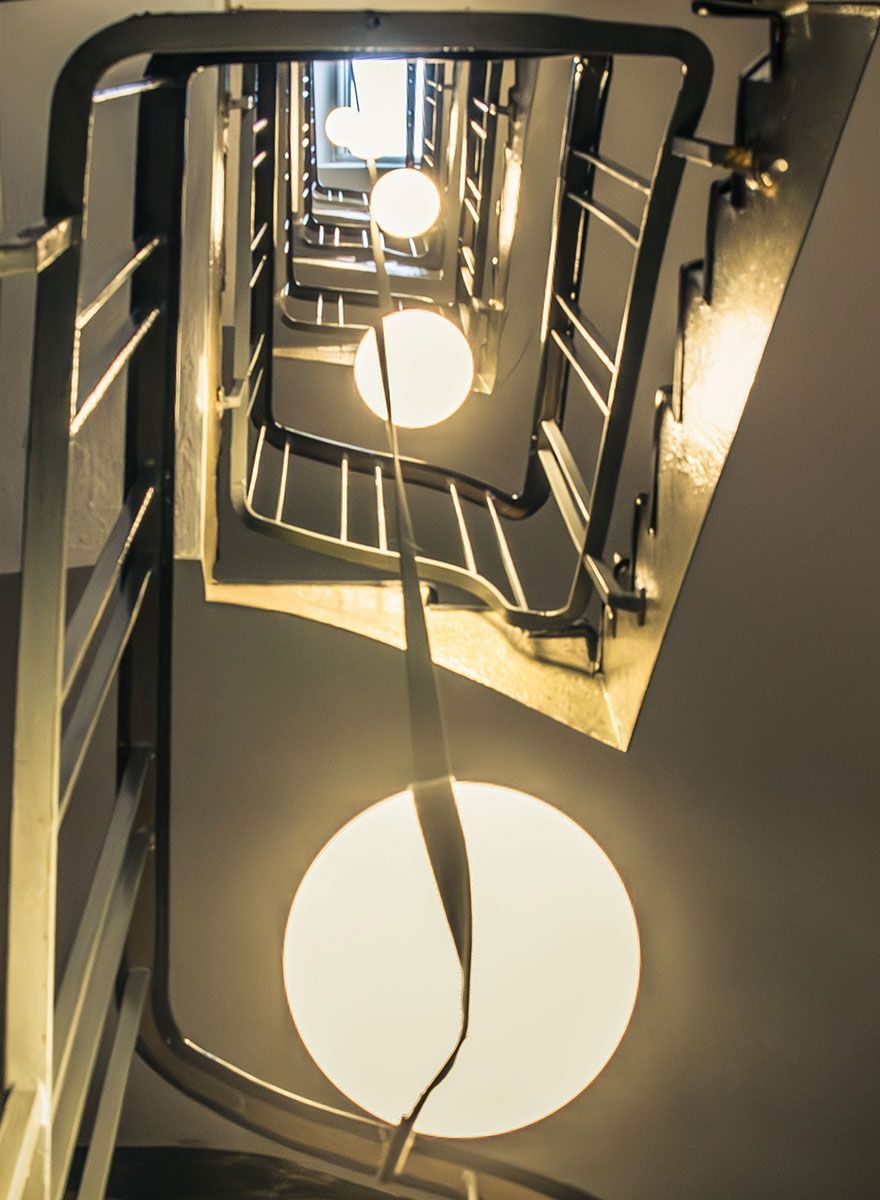Treppenhaus-Lichtplanung mit einer warm strahlenden Pendelleuchte im offenen Treppenauge.