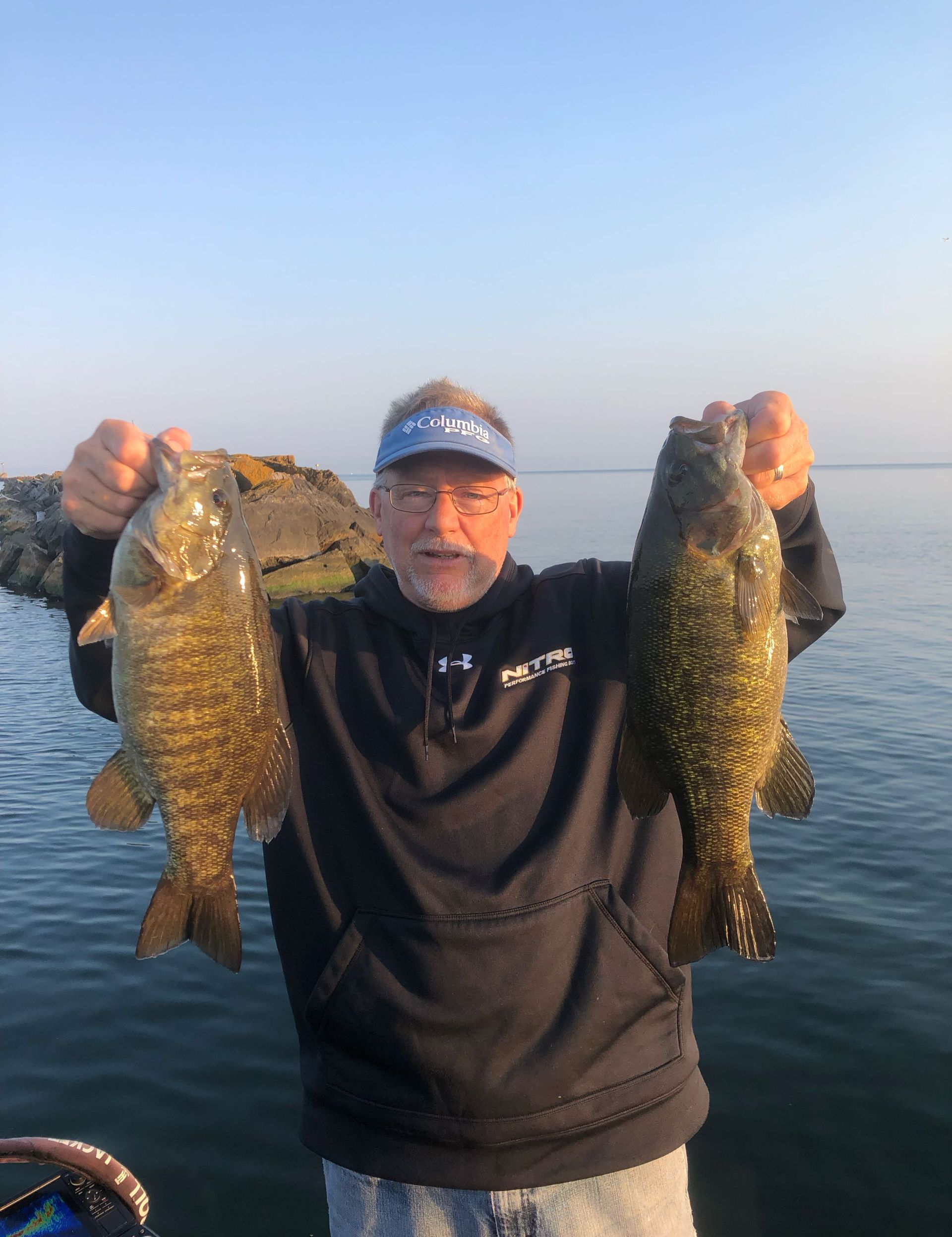 Fisherman holding two smallmouth bass