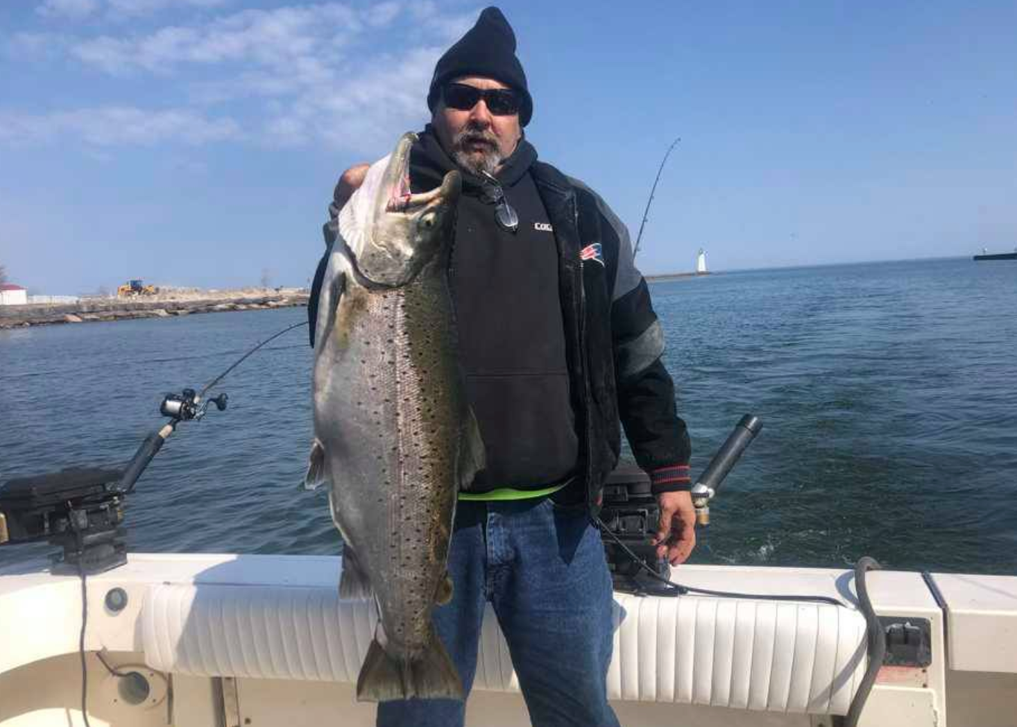 A man is holding a large fish on a boat.