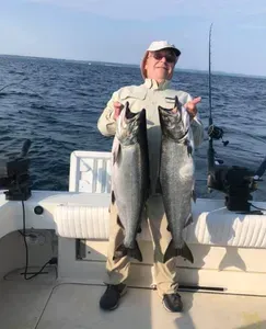 man holding a salmon on a boat