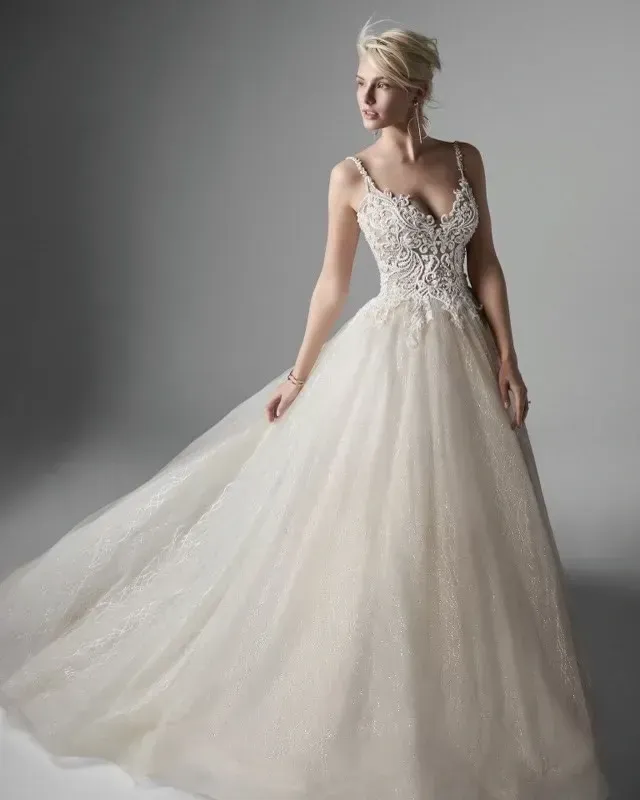 Woman in a white wedding gown, with lace bodice, and flowing tulle skirt.