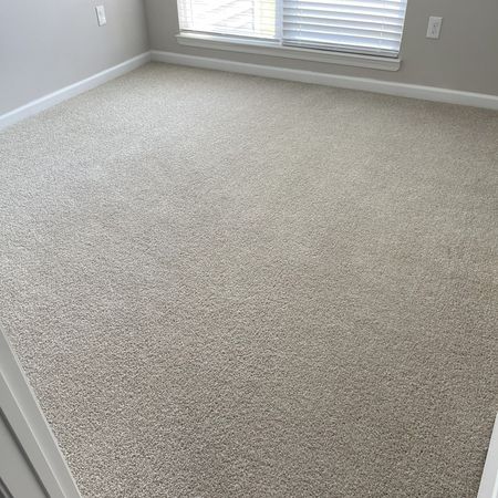 Robert's Cleaning and Restoration - A bedroom with a large carpeted floor and a window.