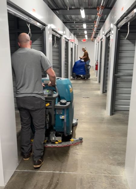 Robert's Cleaning and Restoration - A man is cleaning a hallway with a machine.