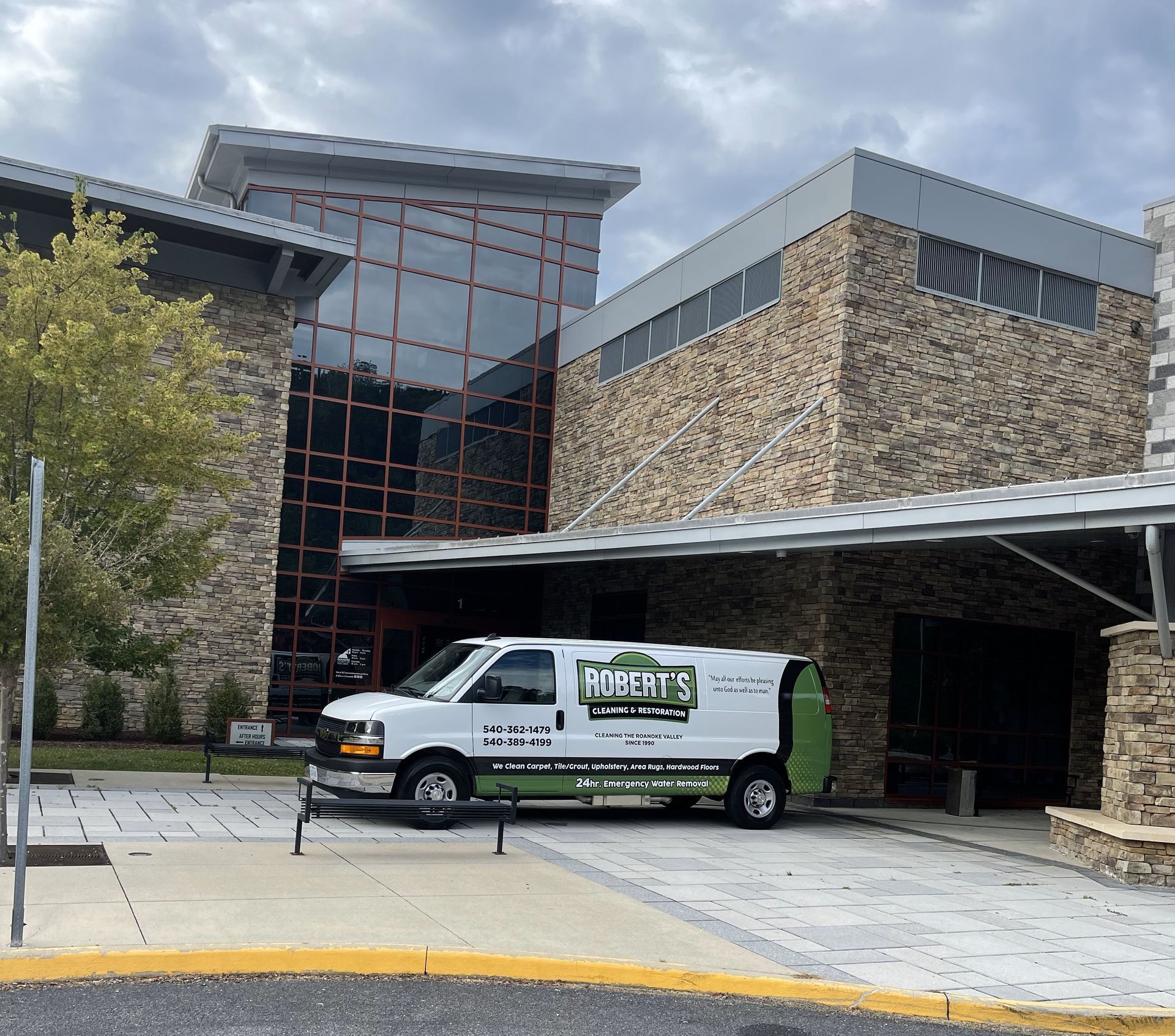 Robert's Cleaning and Restoration - A white van is parked in front of a large stone building