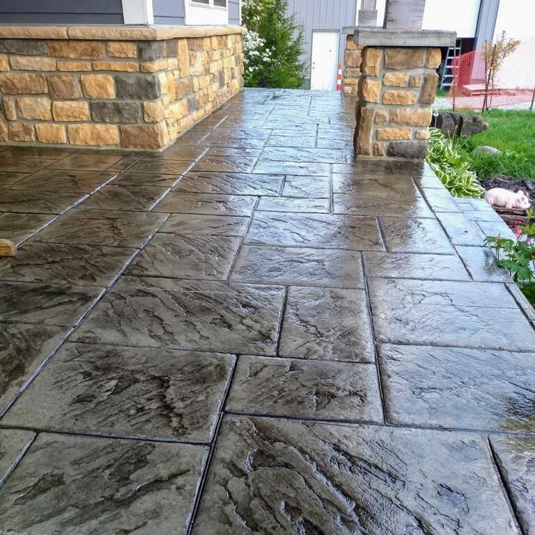 Stamped concrete walkway with a stone pattern, in front of a house.