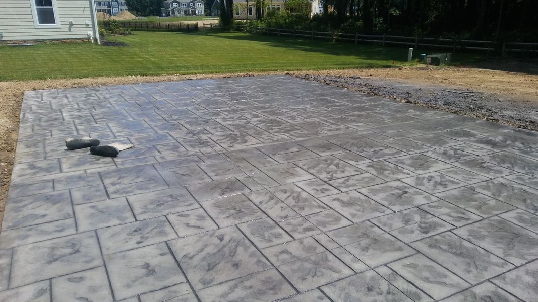 Newly poured gray stamped concrete patio.