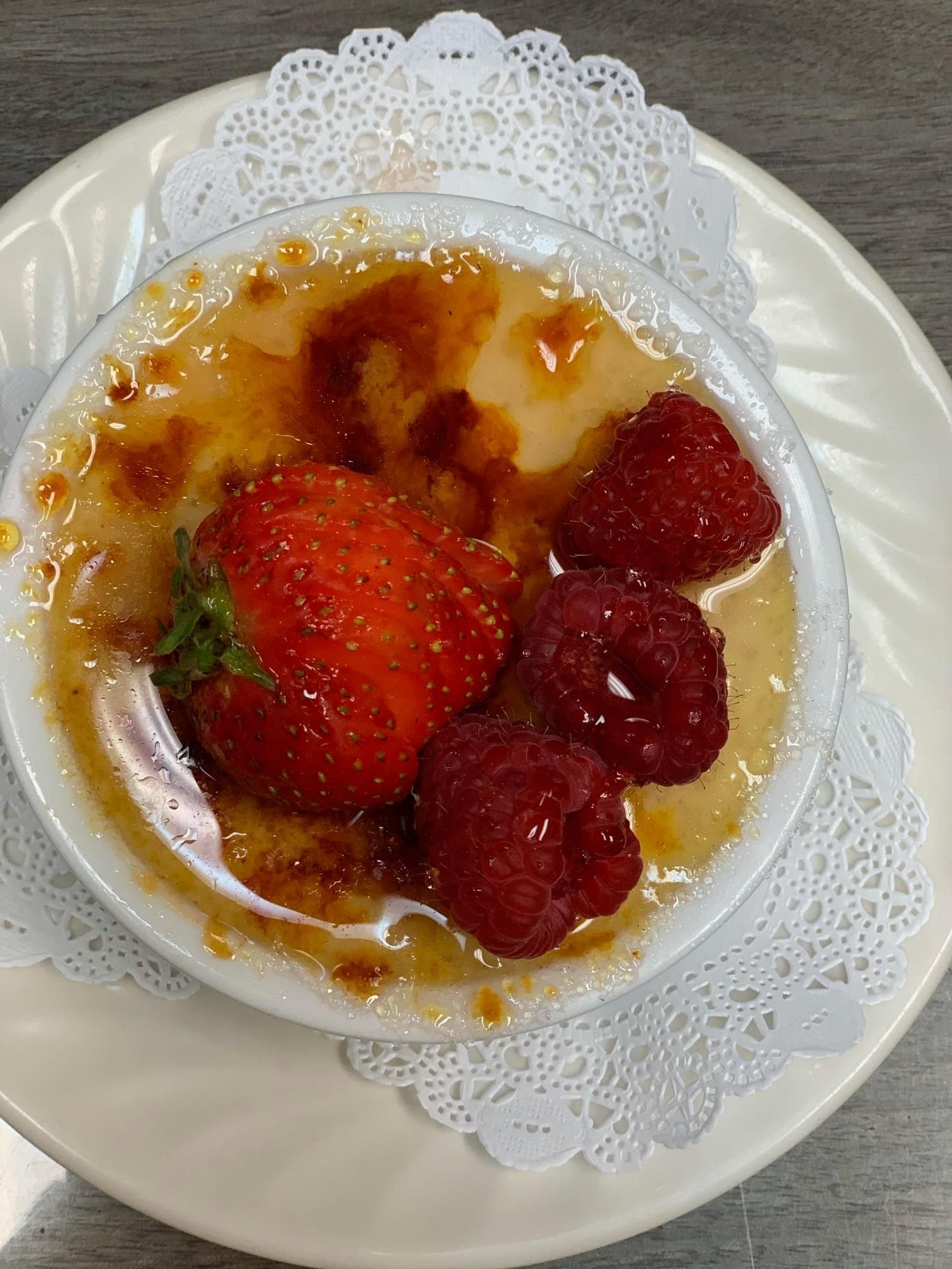 Strawberry dessert in a white bowl on a decorative plate with a doily