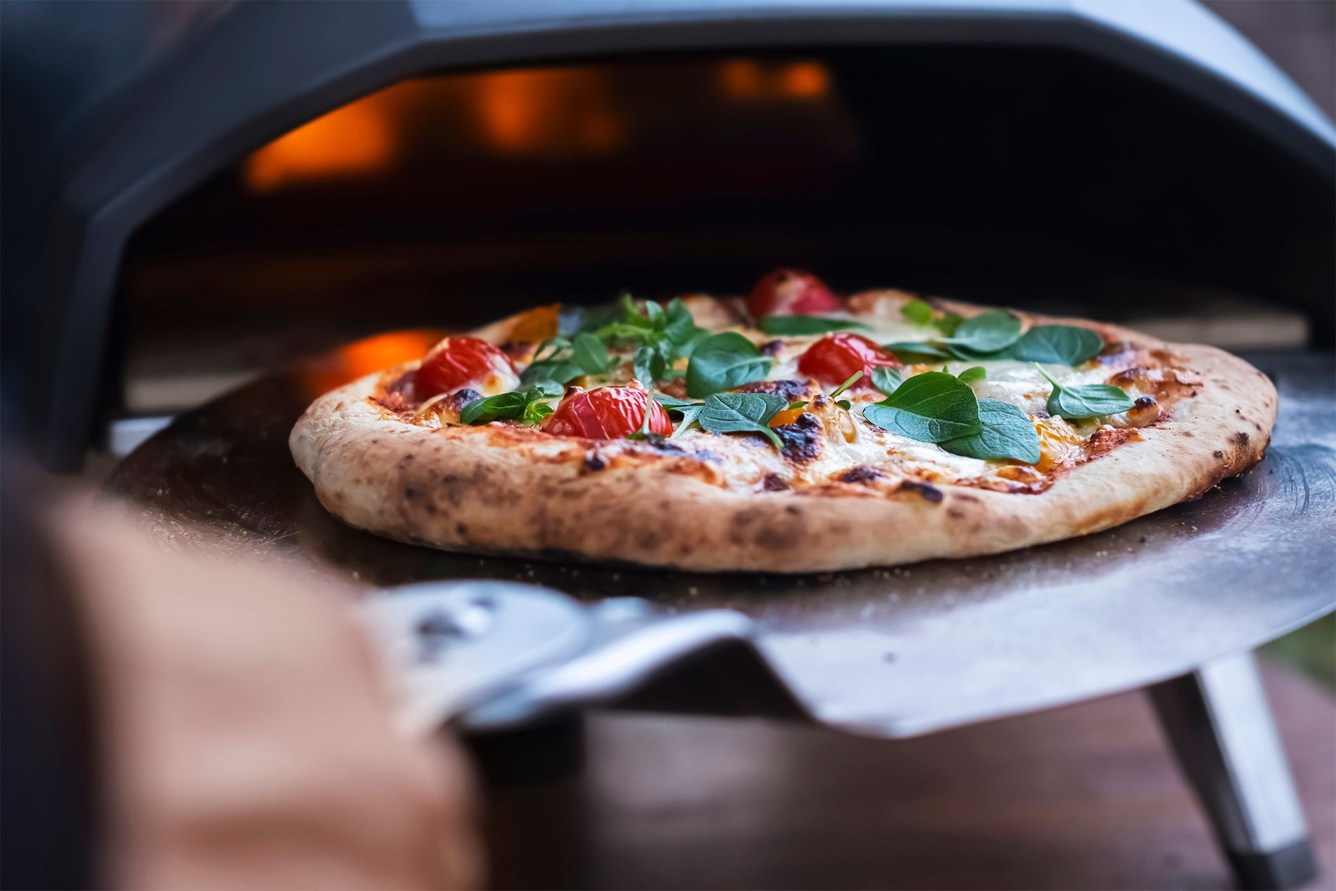 Pizza baking in a wood-fired oven, topped with basil and red peppers. Pizza baking in a wood-fired oven, topped with basil and red peppers.