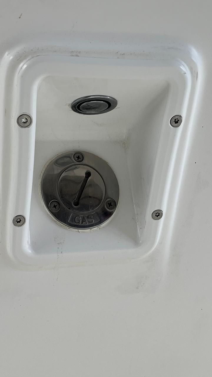 Gros plan sur un panneau électrique encastré blanc avec un interrupteur rond noir et des vis