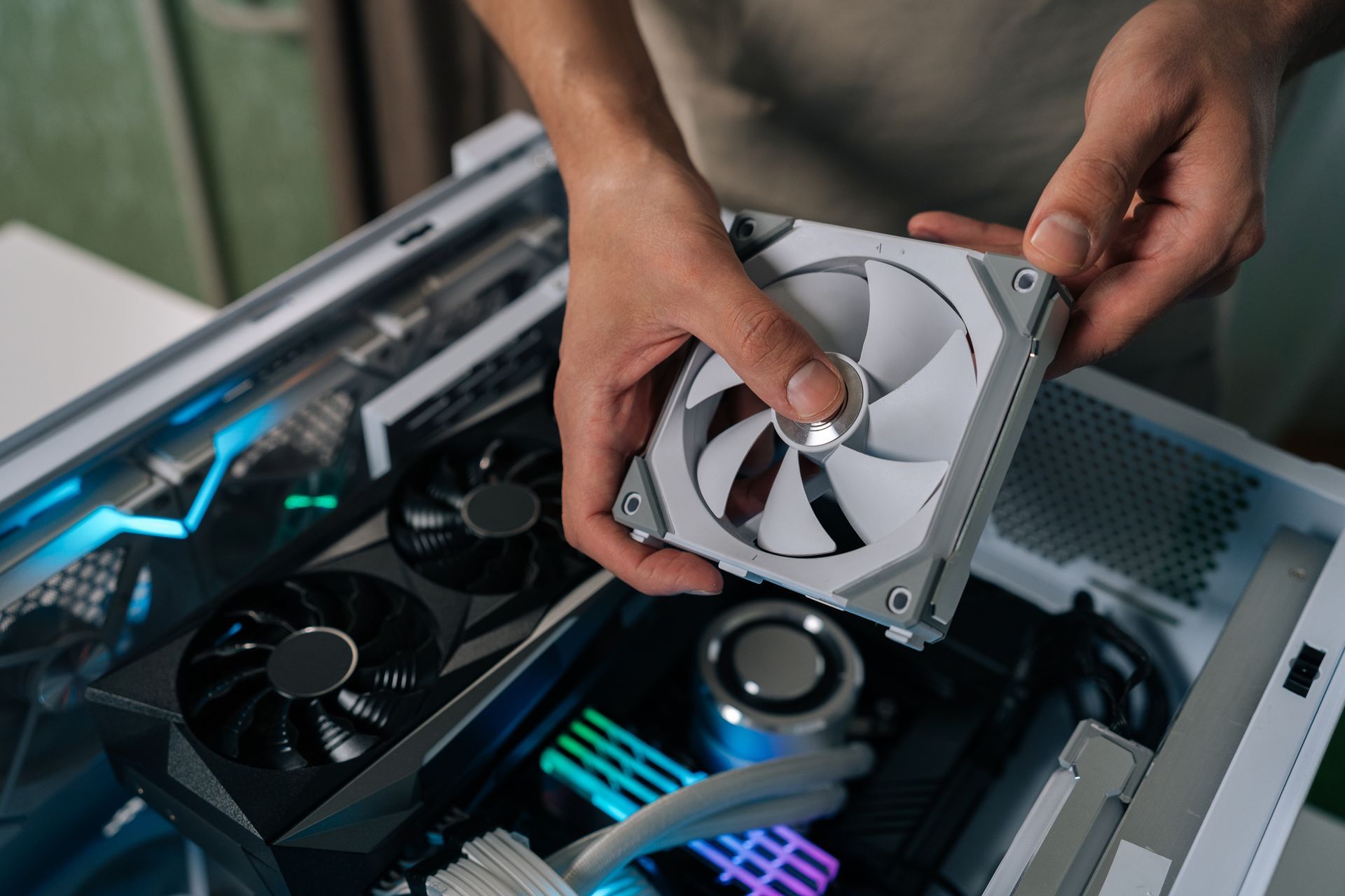 A close-up of a technician holding a computer fan in their hand A close-up of a technician holding a computer fan in their hand