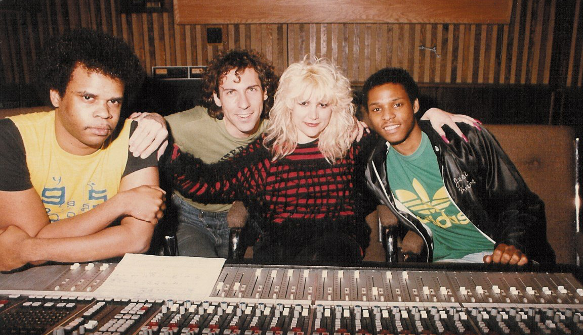A group of people posing for a picture in front of a mixer