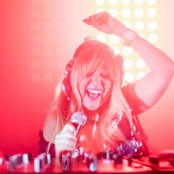 A woman wearing headphones is singing into a microphone