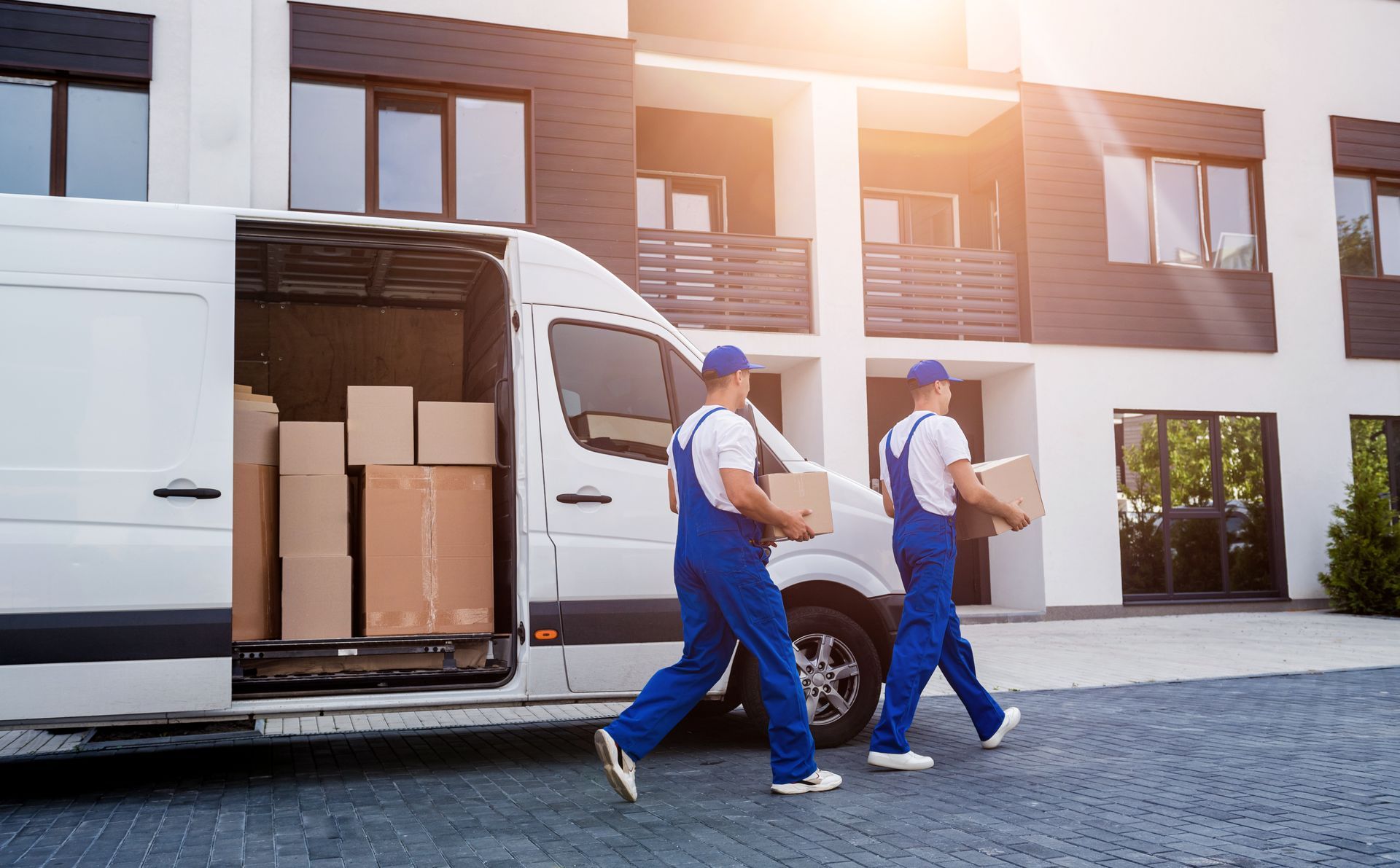 Two men are unloading boxes from a van. Two men are unloading boxes from a van.