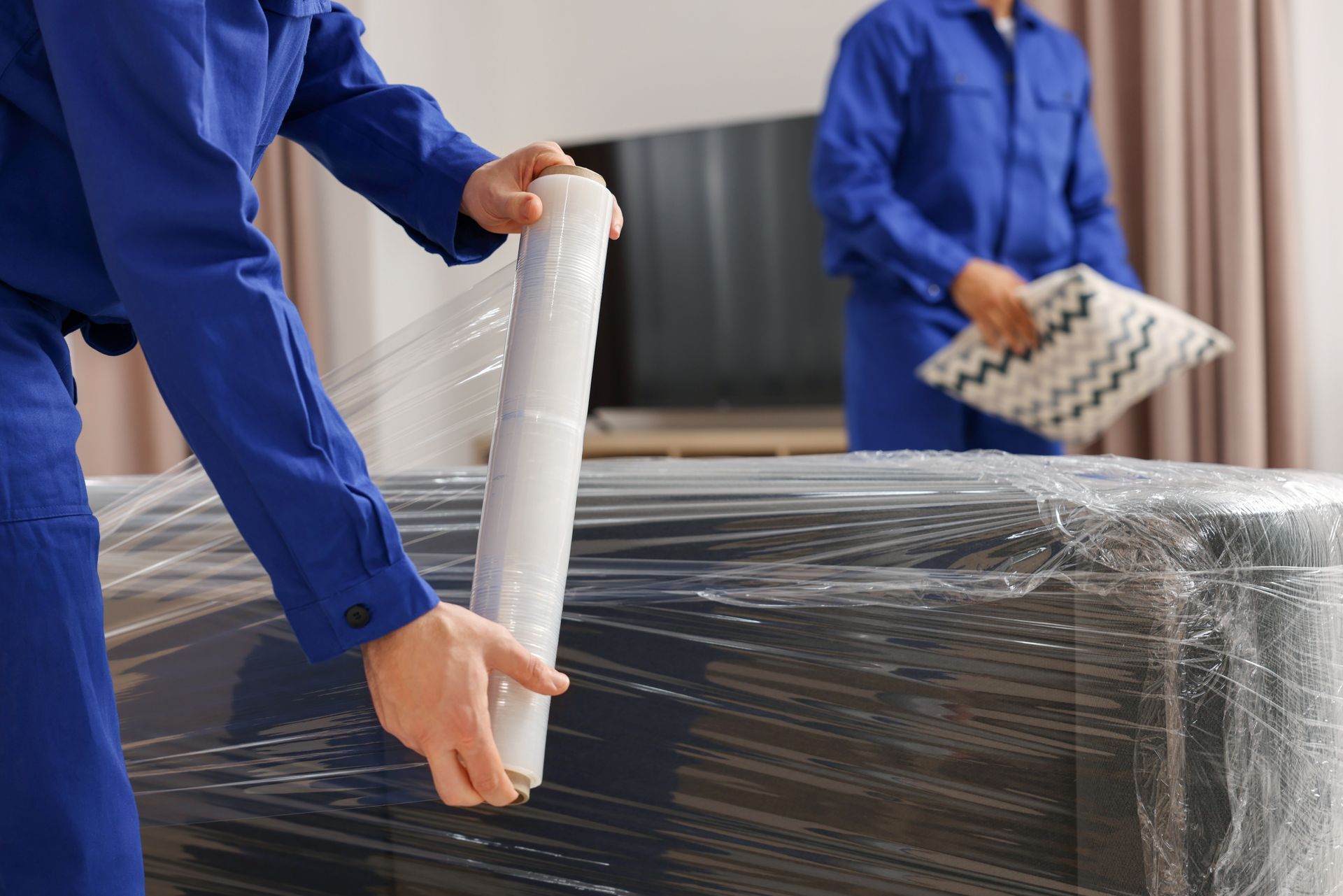 A man is closing a box with duct tape.