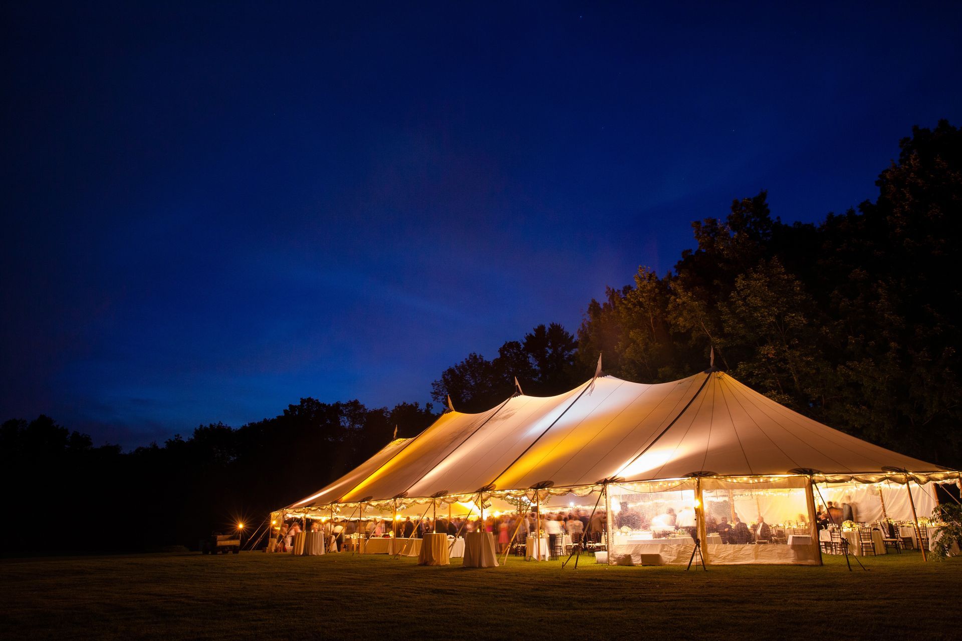Outdoor event tent with rows of chairs arranged on a landscaped lawn, prepared for a wedding. Outdoor event tent with rows of chairs arranged on a landscaped lawn, prepared for a wedding.