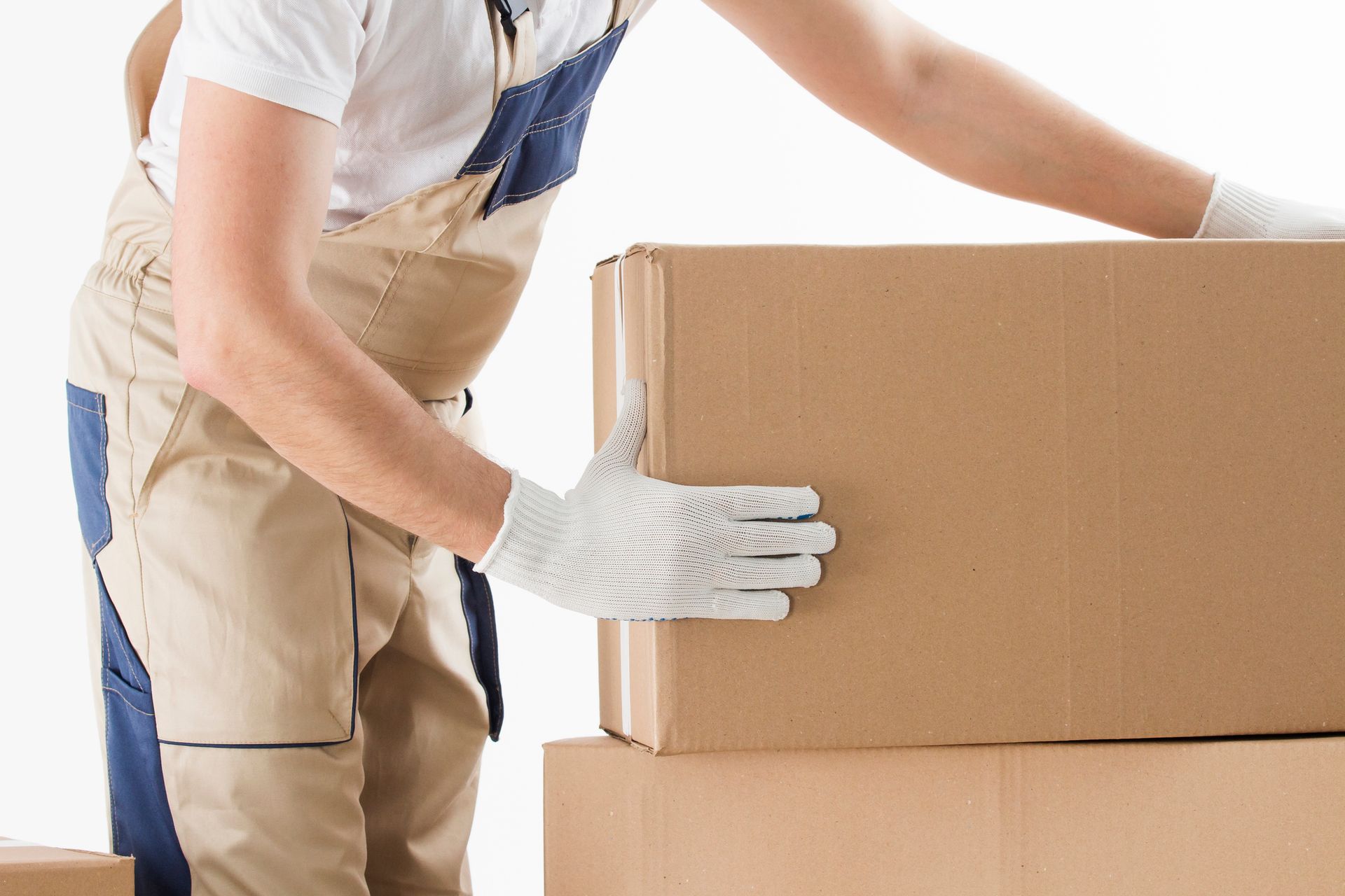 Person in work clothes and gloves lifting a cardboard box.